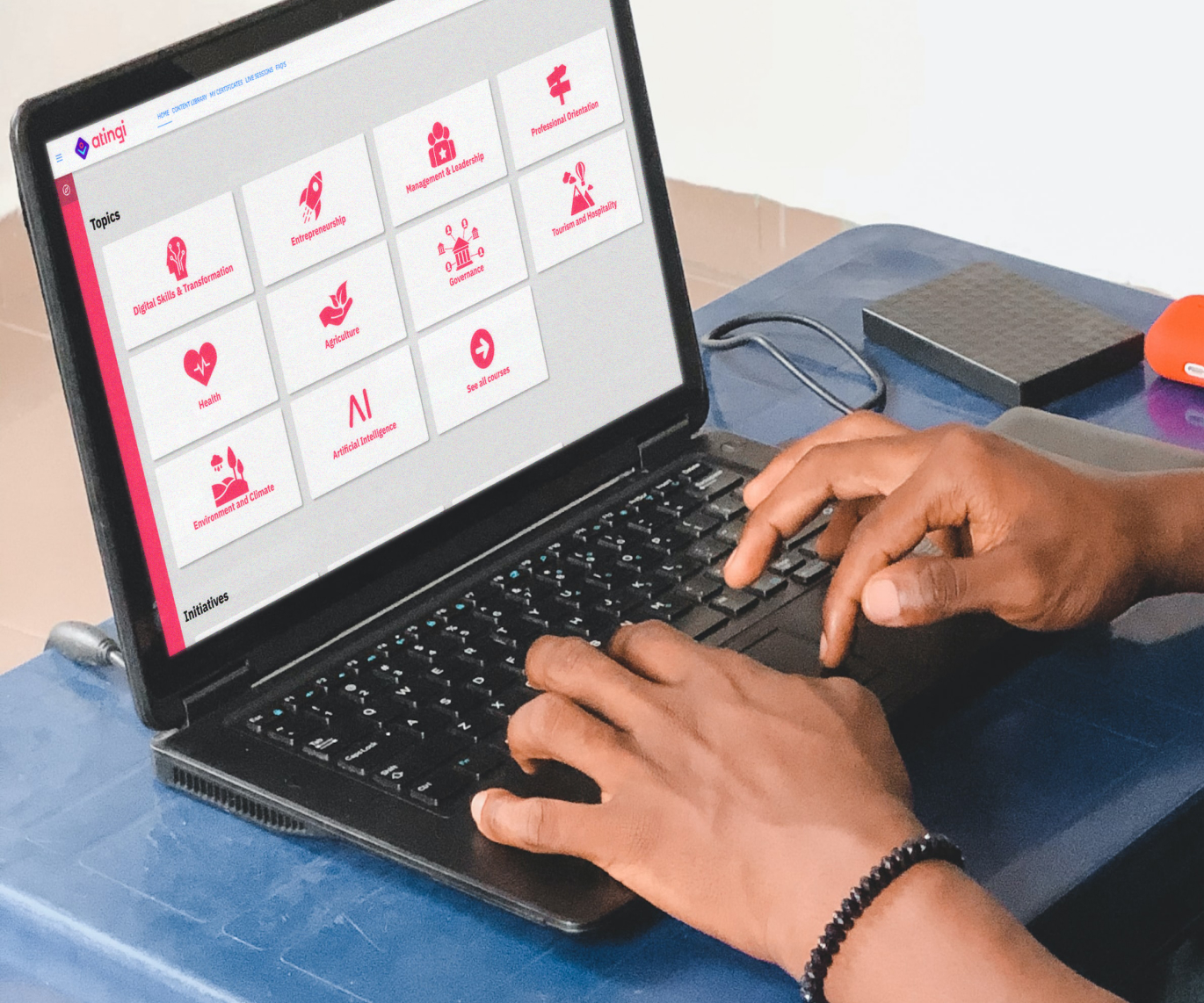 A male student using the atingi platform on his laptop.