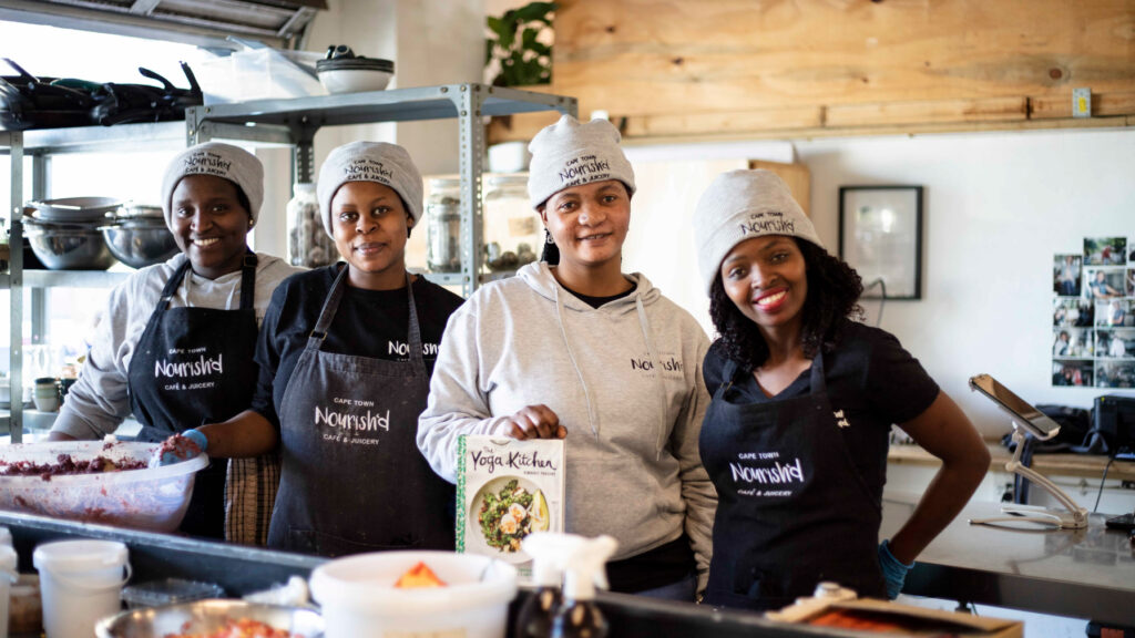 Four female chefs in the kitchen posing for a photo.