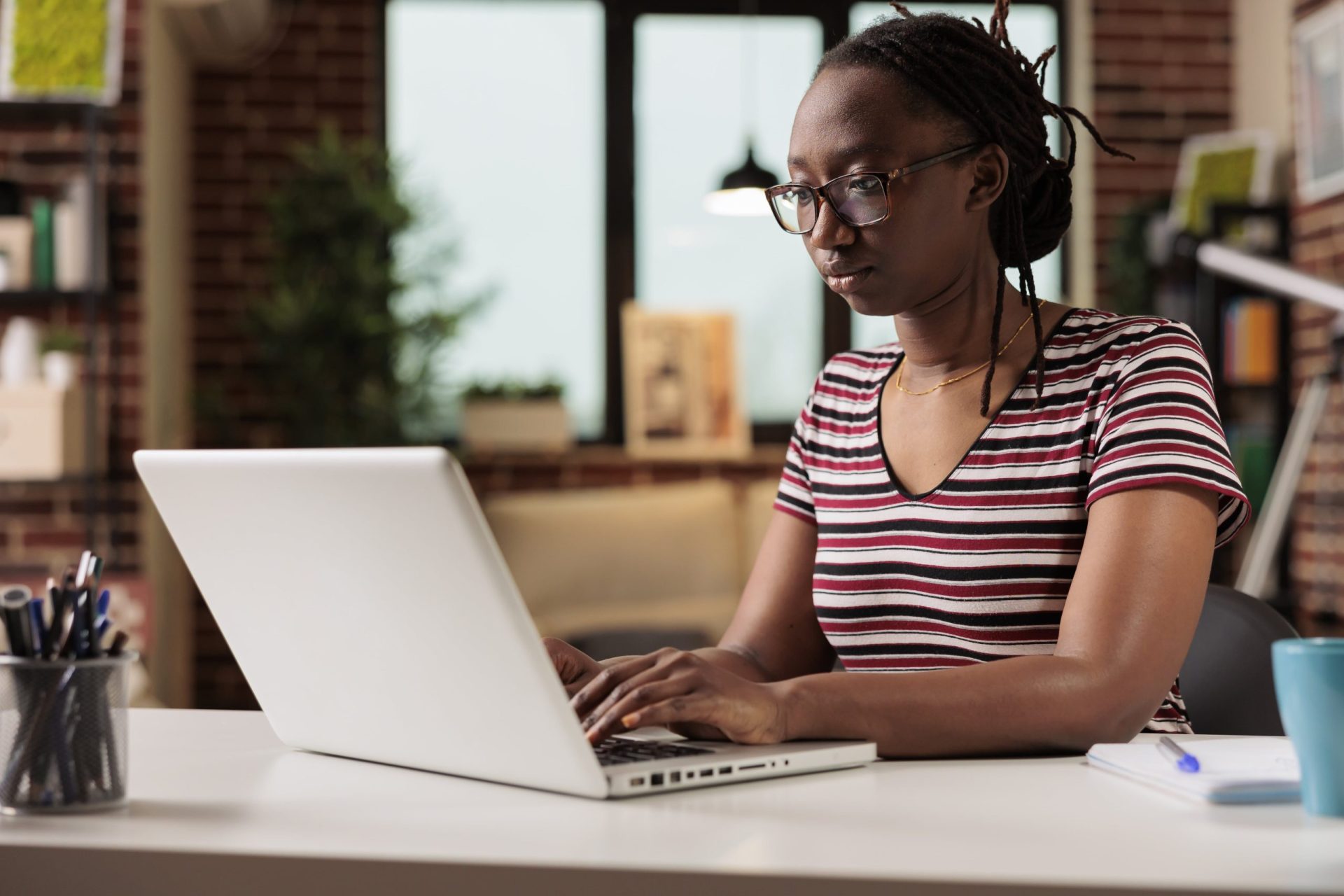 A lady using her MacBook at her office desk.