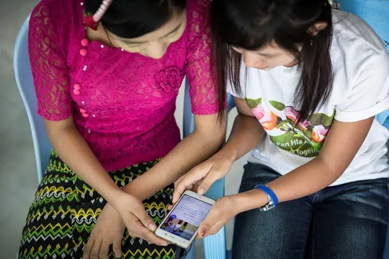 Two ladies viewing content on a phone.