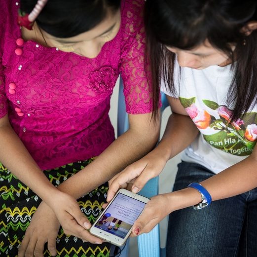 Two ladies viewing content on a phone.